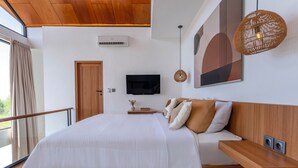 A modern bedroom with a large bed, a mounted TV, and a balcony with curtains. - Dela Villa by Betterplace (Pecatu)