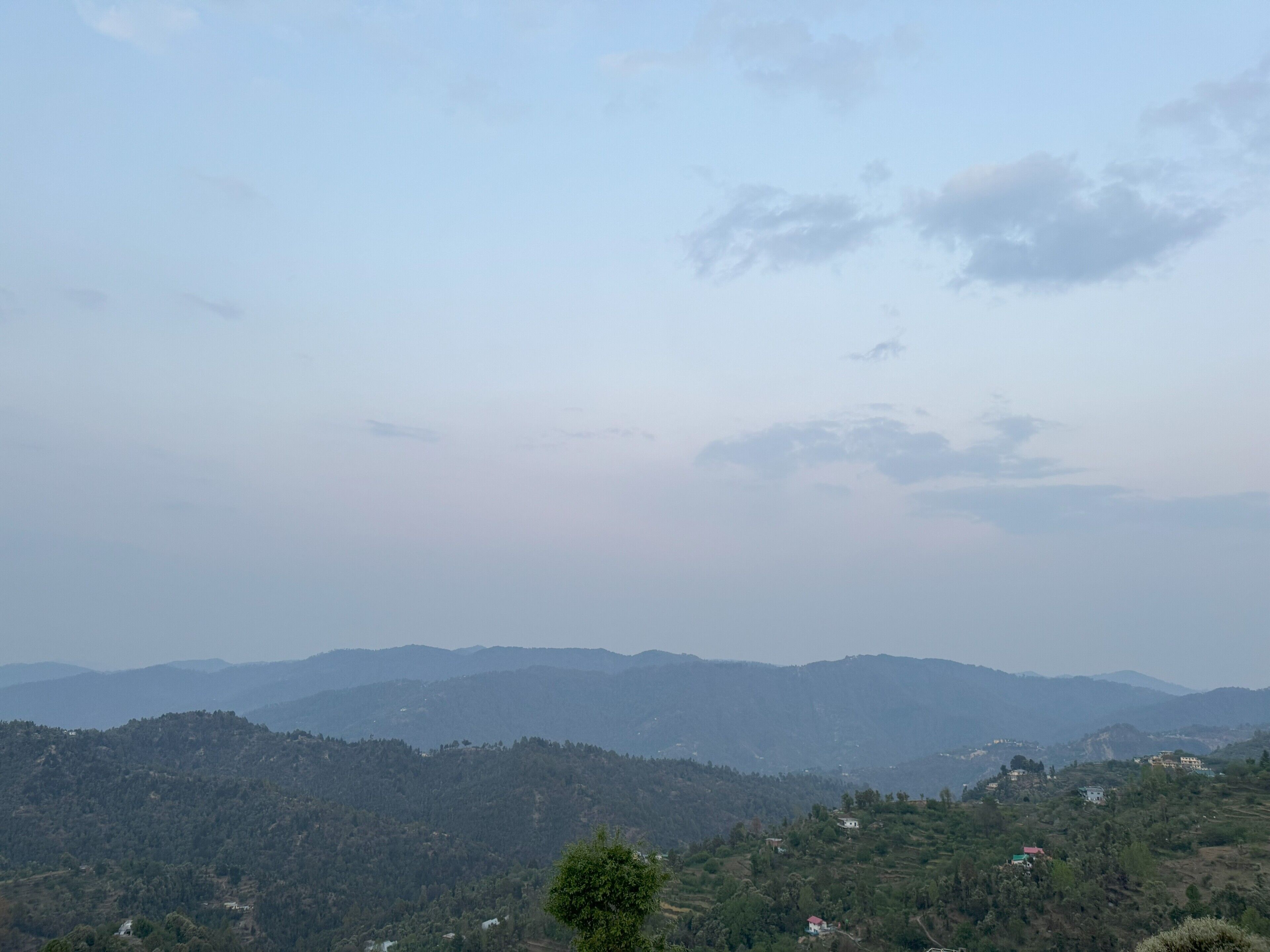 A panoramic view of a mountainous landscape with scattered buildings.