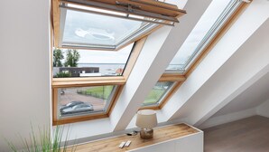 A room with skylights, a wooden desk, and a lamp.