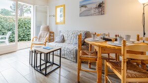 Un salón acogedor con sofá, sillas, una mesa de comedor y un cuadro en la pared.