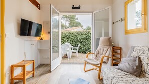 Una sala de estar moderna con un sofá, una silla, una mesita y un televisor instalado en la pared.
