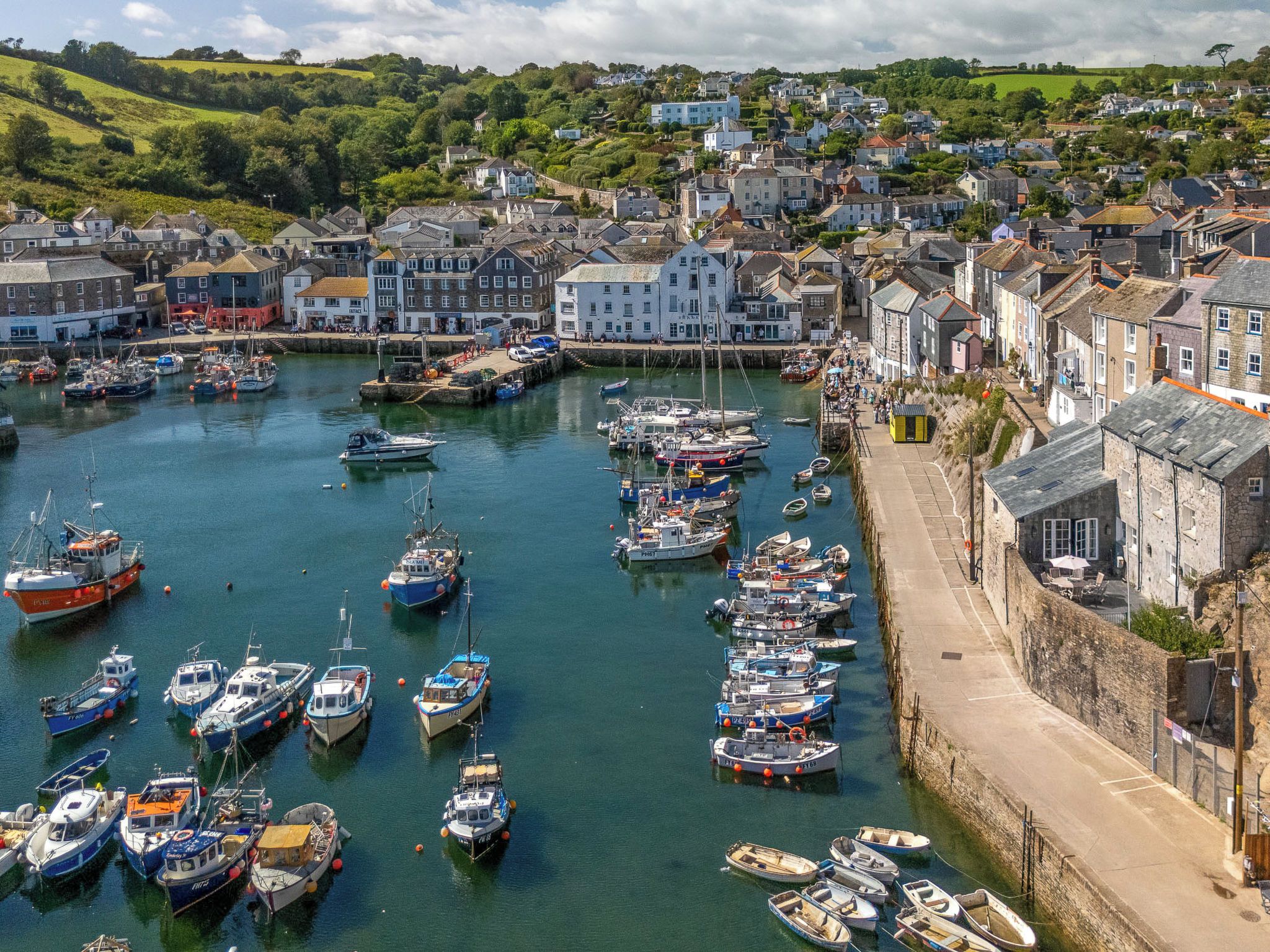 Un port où de nombreux bateaux sont amarrés, entouré d’une ville qui compte de nombreux bâtiments historiques.