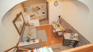Un grand espace de vie comprenant un canapé, une table à manger et une cuisine à l’arrière-plan.