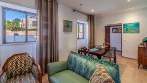 Un salon avec un canapé, une table à manger et une vue sur l’extérieur.