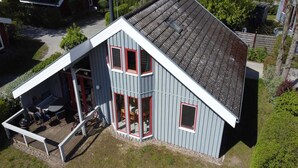 A two-story house with a covered porch and a small deck. - exklusives skandinavisches Ferienhaus (Granzow)
