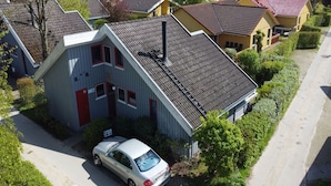 A residential building with a sloped roof, a car parked in front, and a visible chimney. - exklusives skandinavisches Ferienhaus (Granzow)
