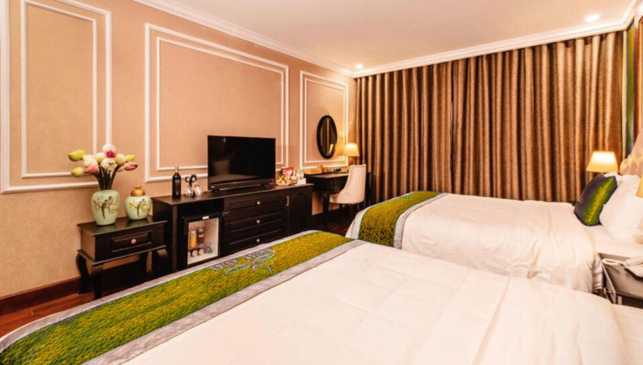 Una habitación de hotel con dos camas, televisión, escritorio y cómoda.