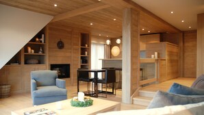 Un salon moderne doté d’une cheminée, d’un coin repas et d’un escalier menant à l’étage supérieur.