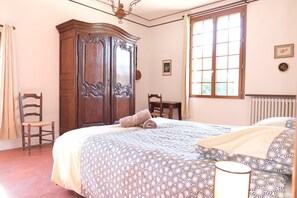 A bedroom with a large bed, a wooden wardrobe, a chair, and a window with curtains. - Vacation rental house with pool MOURIES LS1-361 (Mouriès)