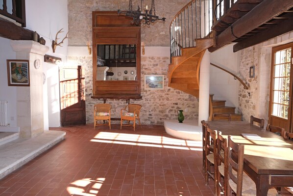 A rustic interior with a stone wall, wooden staircase, and a dining area with a large table and chairs. - Vacation rental house with pool MOURIES LS1-361 (Mouriès)