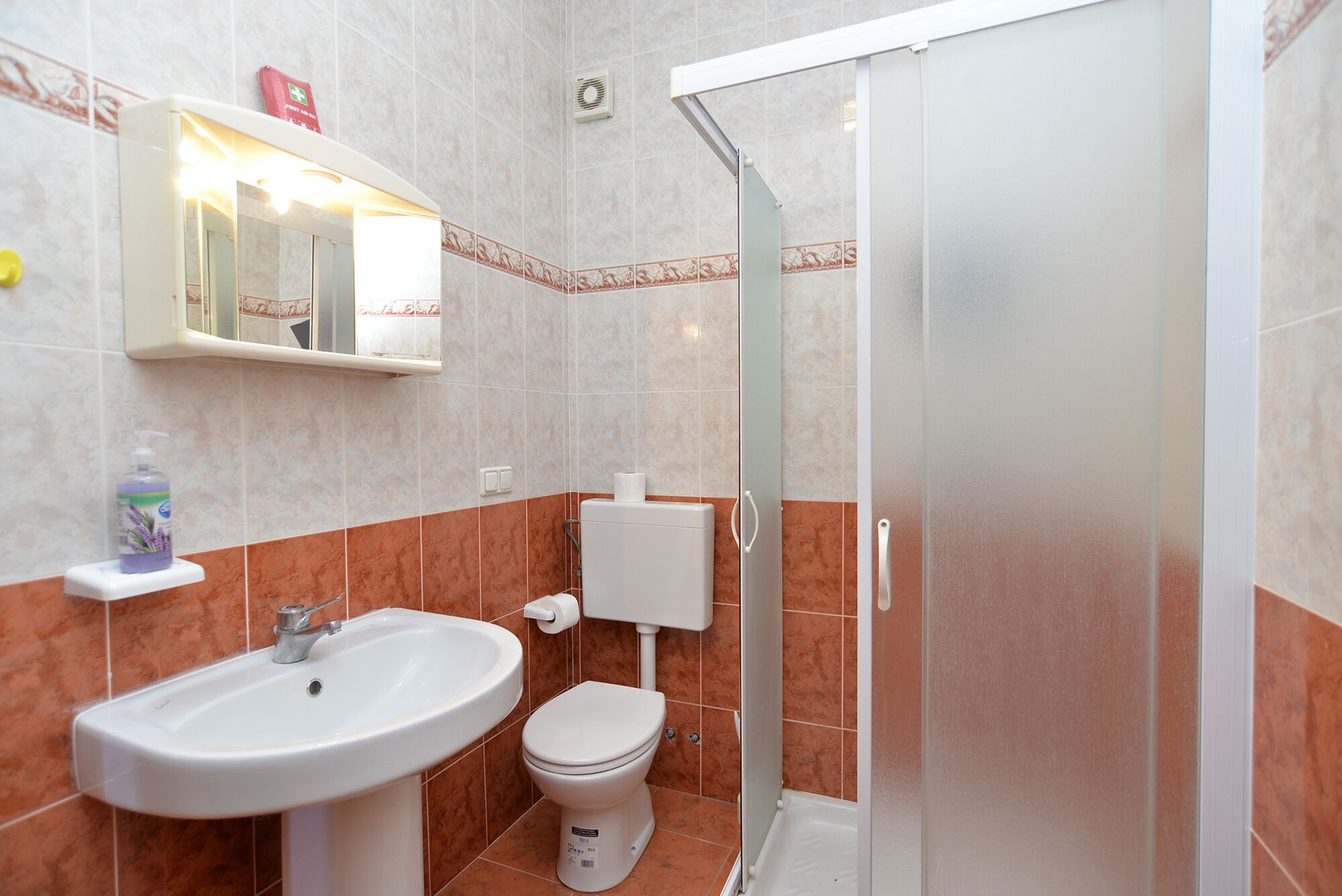 A bathroom with a sink, toilet, and shower.