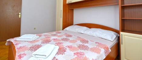 Un dormitorio con cama, cabecera de madera y estanterías empotradas.