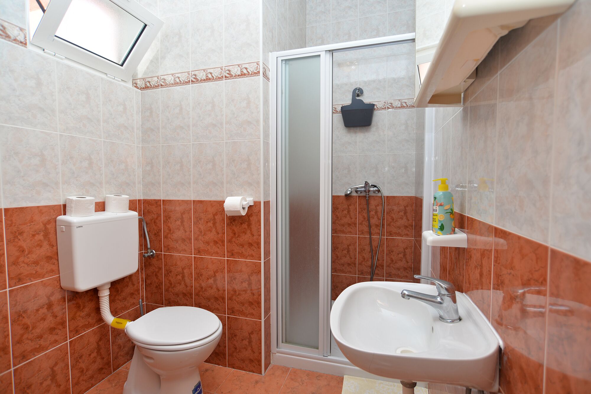 Un baño con inodoro, ducha y lavamanos.