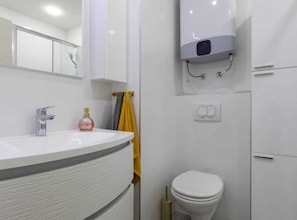 A modern bathroom with a white sink, a toilet, and a shower area. - Kastel Stari Sunny Downtown Apartment With Terrace (Kastela)