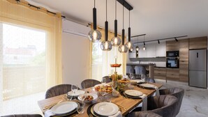 Ein stilvoller Essbereich mit einem Holztisch, gedeckt für eine Mahlzeit, umgeben von grauen Sitzmöglichkeiten.