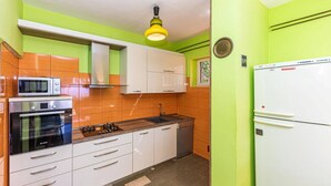 A compact kitchen with white cabinets, a microwave, a stove, and a refrigerator. - Holiday Home by the Sea With Terrace & Ocean Views on Čiovo (Okrug)