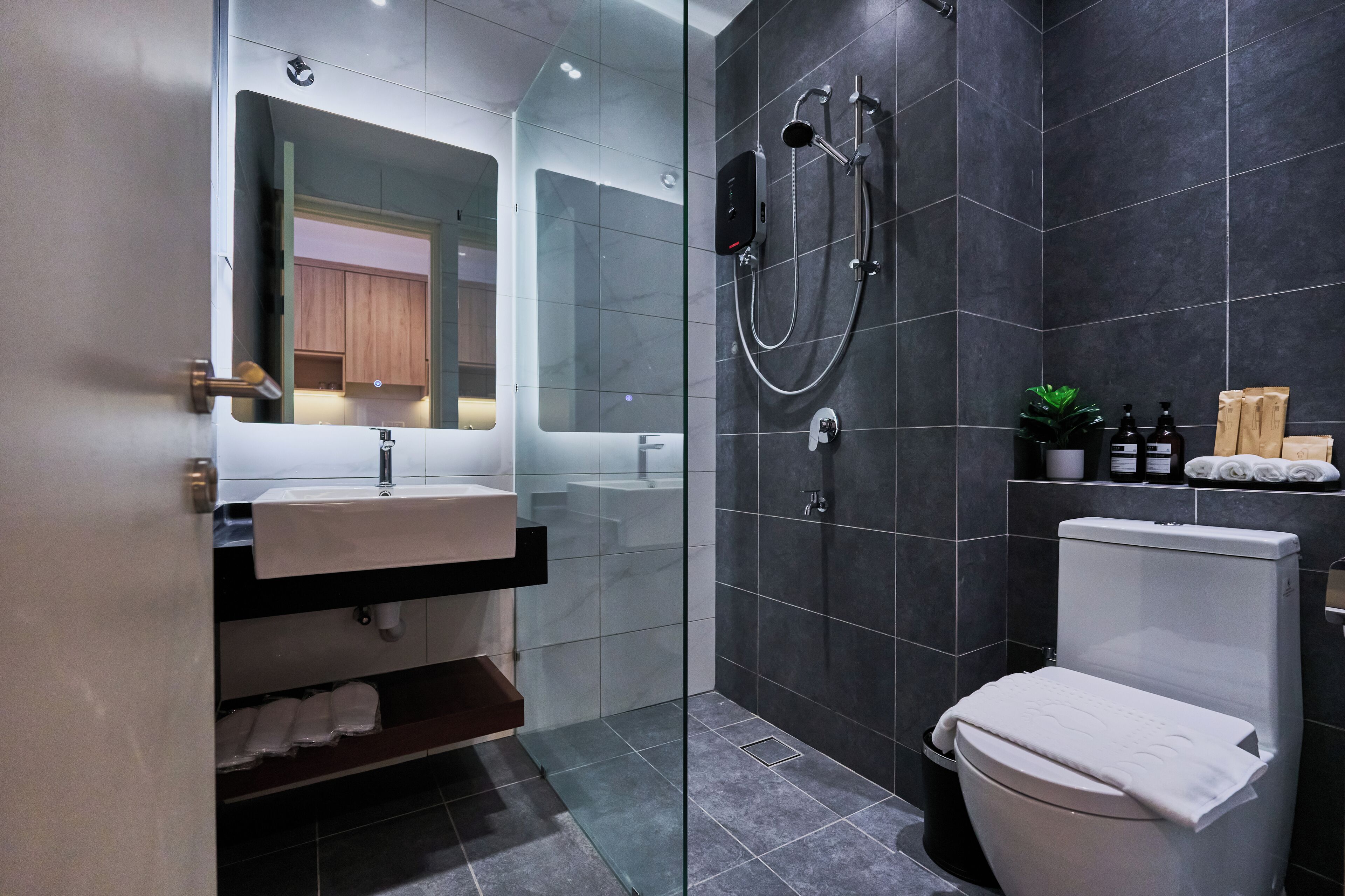 Ein modernes Badezimmer mit einer Duschkabine, einem weißen Waschbecken und einer Toilette.