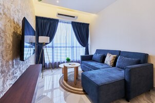 A modern living room with a sofa, a coffee table, and a TV mounted on the wall.