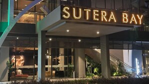 Ein modernes Gebäude mit einem auffälligen Schild, auf dem "Sutera Bay" steht.
