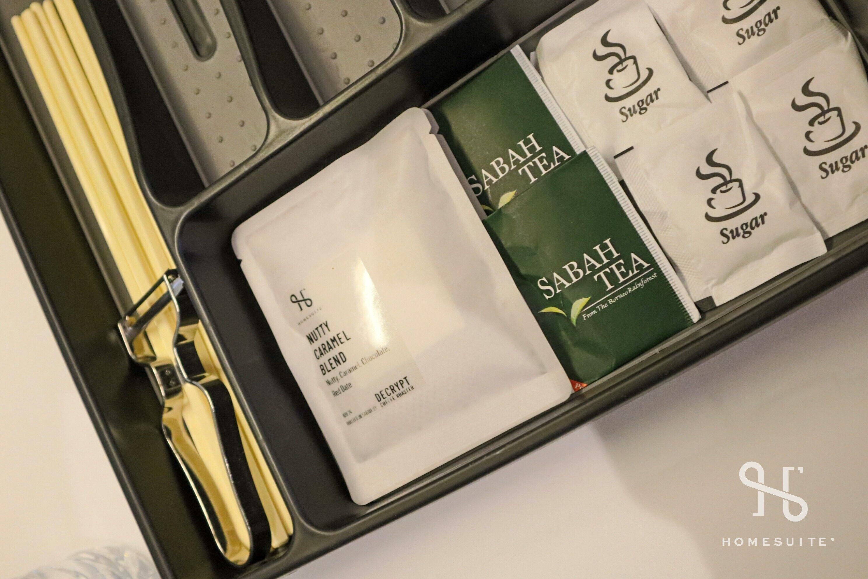 A tray with a tea set including a sugar packet, a tea bag, and a napkin.