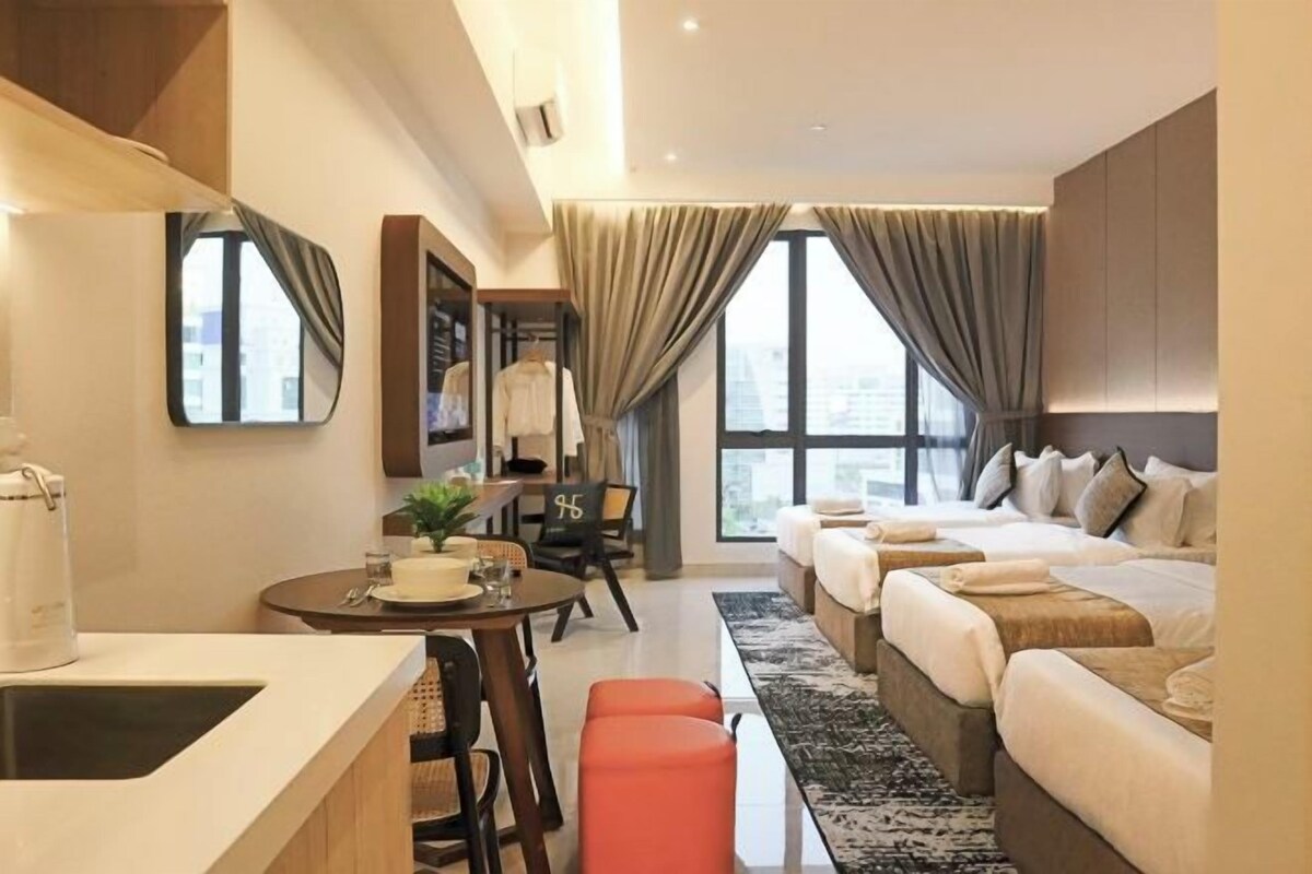 A modern hotel room with a dining area, a sofa bed, and a view of the city.