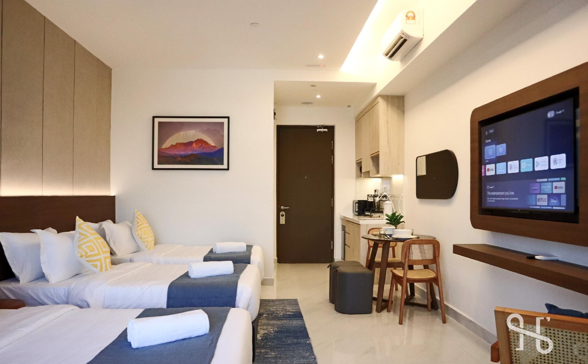 Habitación de hotel con dos camas, televisión, escritorio y un cuadro.
