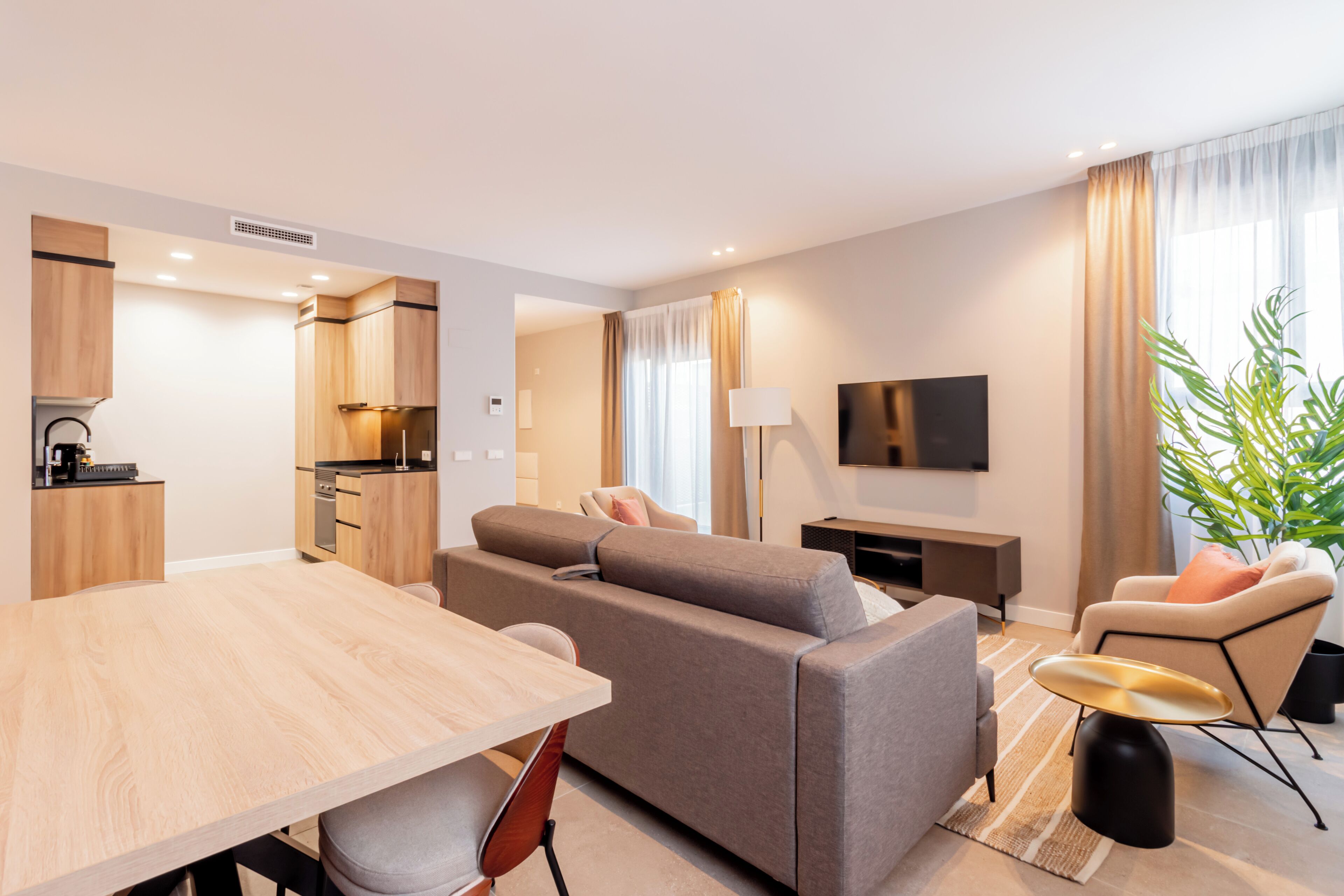 Una sala moderna con un sofá, una mesa de comedor y un televisor.