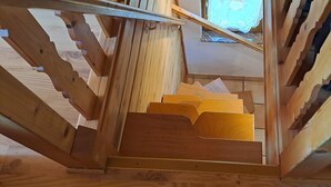Un escalier en bois, doté d’une main courante et de marches en bois.