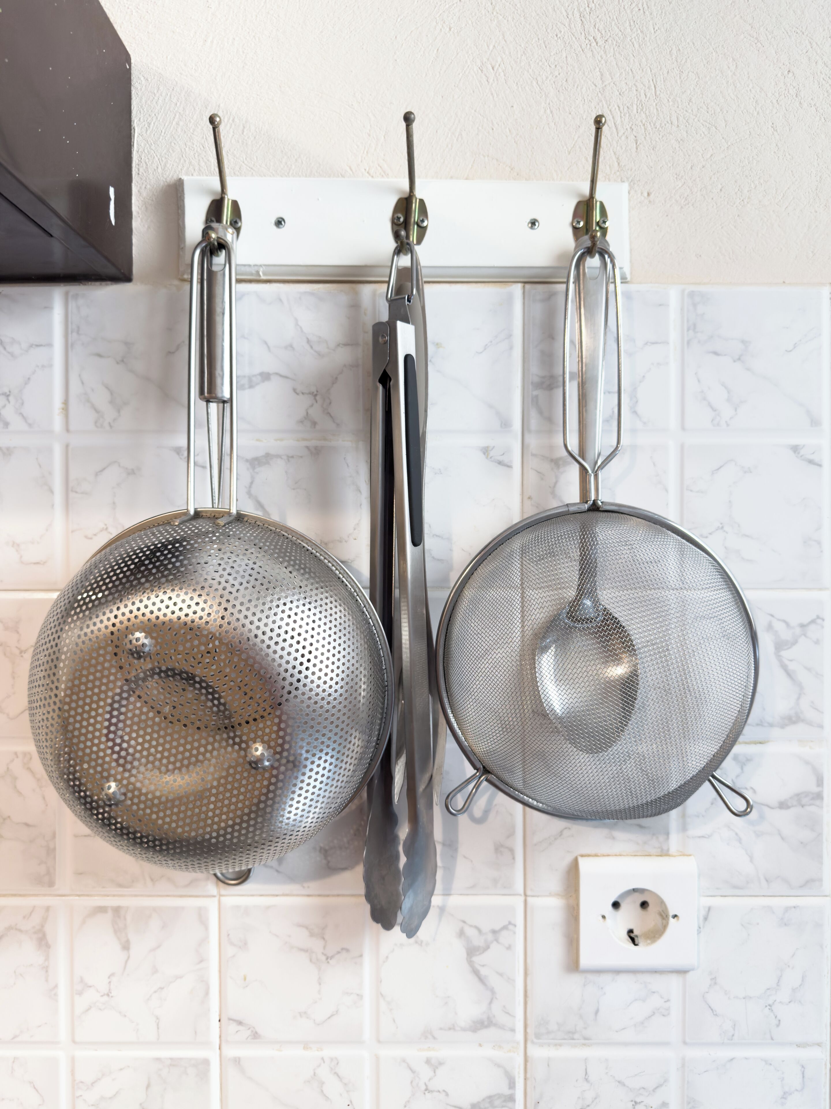 Kitchen utensils hanging on a rack.
