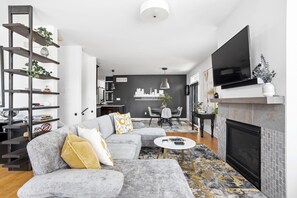 TV connectée, cheminée, livres, écrans d'ordinateur