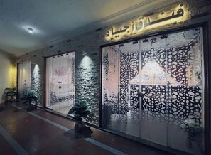 A hallway with decorative panels and a sign with Arabic script. - Agiad Hotel (Al Arish)