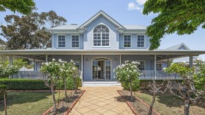 A two-story house with a covered porch, a central arched window, and a symmetrical facade. - Chateau On Vines ~ Aldinga - Welcome to Chateau On Vines (Aldinga)