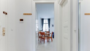A hallway leading to a dining area with a table and chairs.