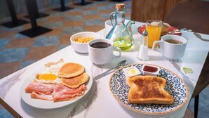 A breakfast table with eggs, bacon, toast, coffee, and juice. - VTZ Hotel El Príncipe (Zaragoza)