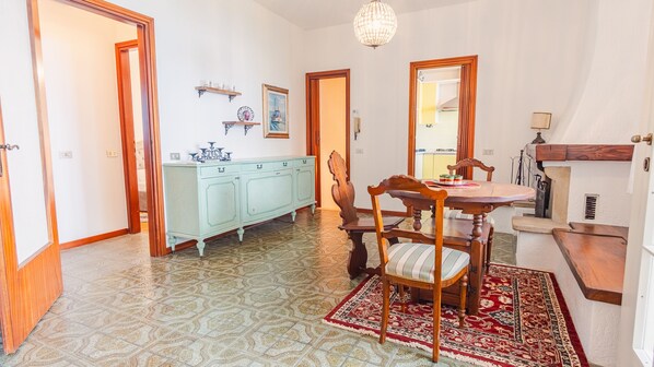 A dining area with a wooden table, chairs, a patterned rug, a light blue cabinet, and a chandelier. - Villa Castlegrace Lake Garda - Italian Homing (Padenghe sul Garda)