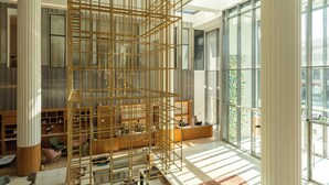 Ein modernes Interieur mit einer Holzgitterstruktur, großen Fenstern und einer Rezeption.