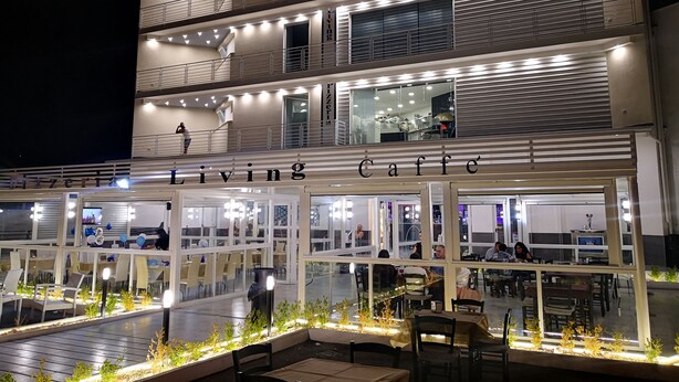 A multi-story building with a cafe named "Living Caffe" on the ground floor. - Living (Casoria)