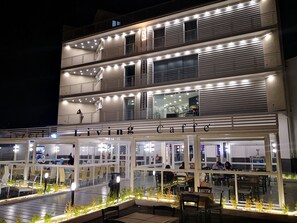 Un edificio a più piani con un caffè chiamato "Living Caffe" al piano terra.