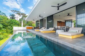 A modern outdoor pool area with built-in seating and ceiling fans. - Luxury-3-suites-100 MB-Ocean views-Ojochal-Private (Ojochal)
