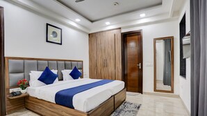 Un dormitorio moderno con una cama grande, un armario de madera y un espejo.