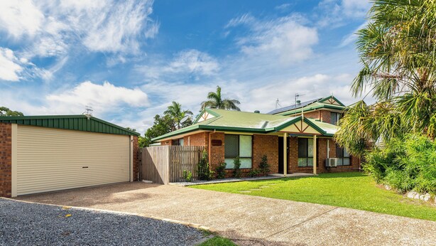 A residential house with a garage, a well-maintained lawn, and a clear sky. - Welcome to "Seascapes" (Gympie)