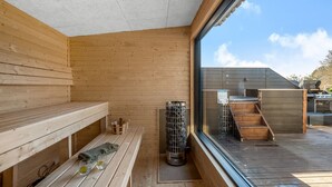 A wooden sauna room with benches and a glass door leading outside. - "Elisaveta" - 400m to the fjord by Interhome (Vemb)