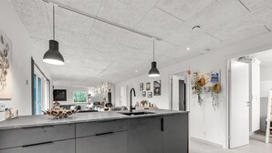 A modern kitchen with a large island, pendant lighting, and a view into the living area. - "Elisaveta" - 400m to the fjord by Interhome (Vemb)