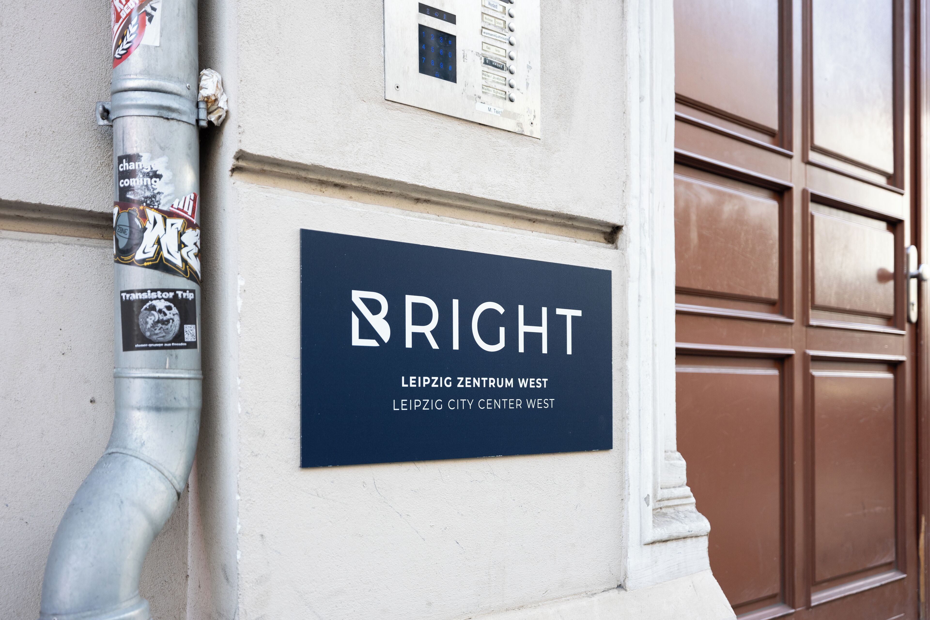 A sign for 'BRIGHT LEIPZIG ZENTRUM WEST' on a building facade.