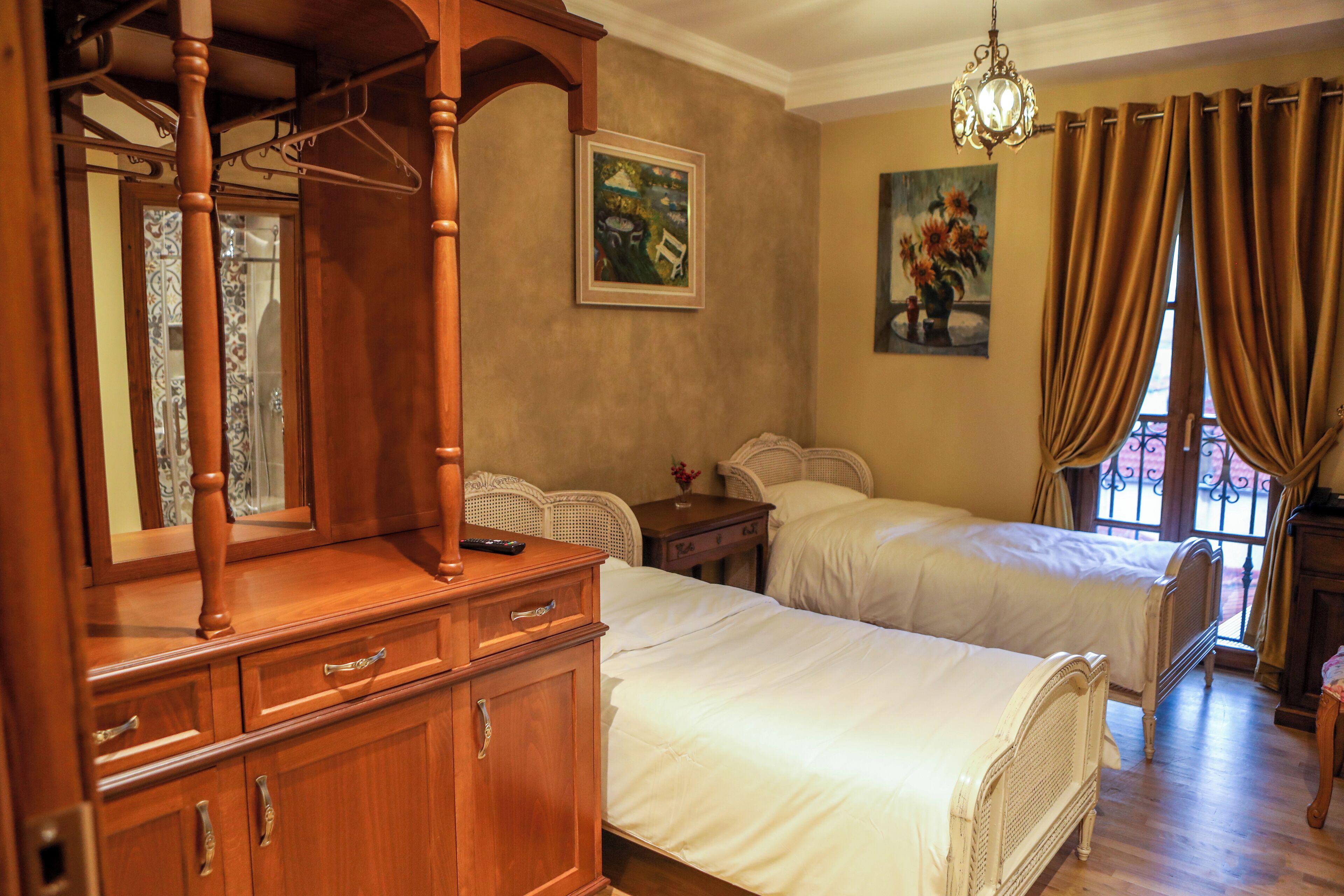 Un dormitorio con dos camas, muebles de madera y obras de arte en las paredes.