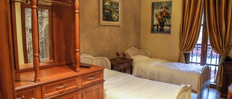 Un dormitorio con dos camas, muebles de madera y obras de arte en las paredes.