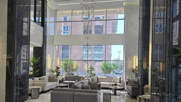 A spacious lobby with a large seating area, marble flooring, and large windows offering views of the cityscape. - Al Jabri Hotel (Makkah)