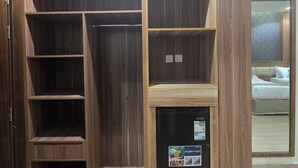 A walk-in closet with multiple shelves and a built-in appliance. - Al Jabri Hotel (Makkah)