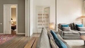 A living room with a grey sofa set, a patterned rug, and a wooden floor. - En Casa de Girona 17 (Barcelona)