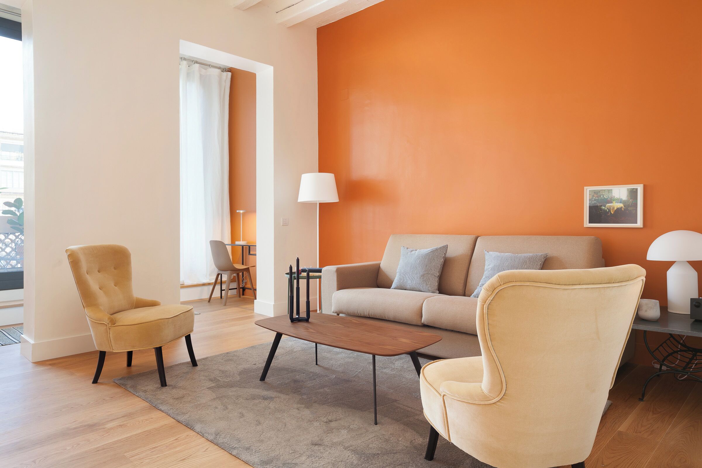 Ein Wohnzimmer mit einer Couch, zwei Sesseln, einem Couchtisch und einer Lampe.
